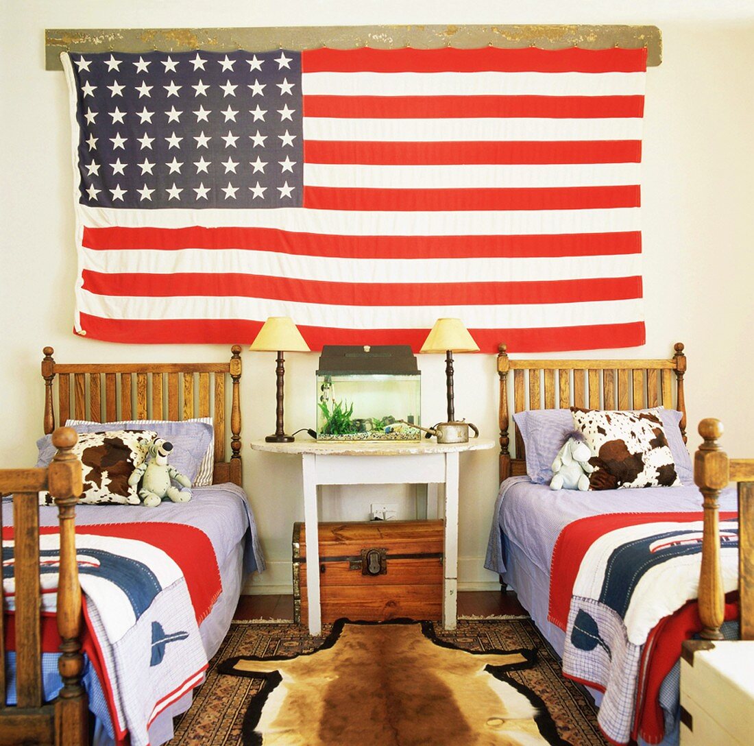 Die Wand des Kinderzimmers mit zwei antiken Einzelbetten ziert eine übergroße USA Flagge