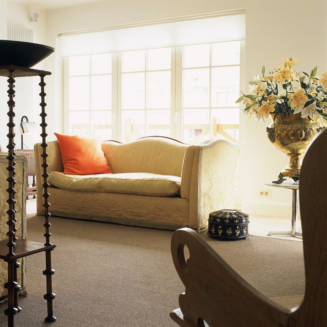 Elegante Antikmöbel im Wohnzimmer mit Zugang zum Balkon durch breite Sprossentüren