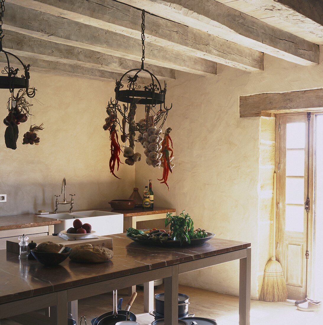 Einfache Kücheneinrichtung und hängende Hakenaufbewahrung in einem urigen Bauernhaus