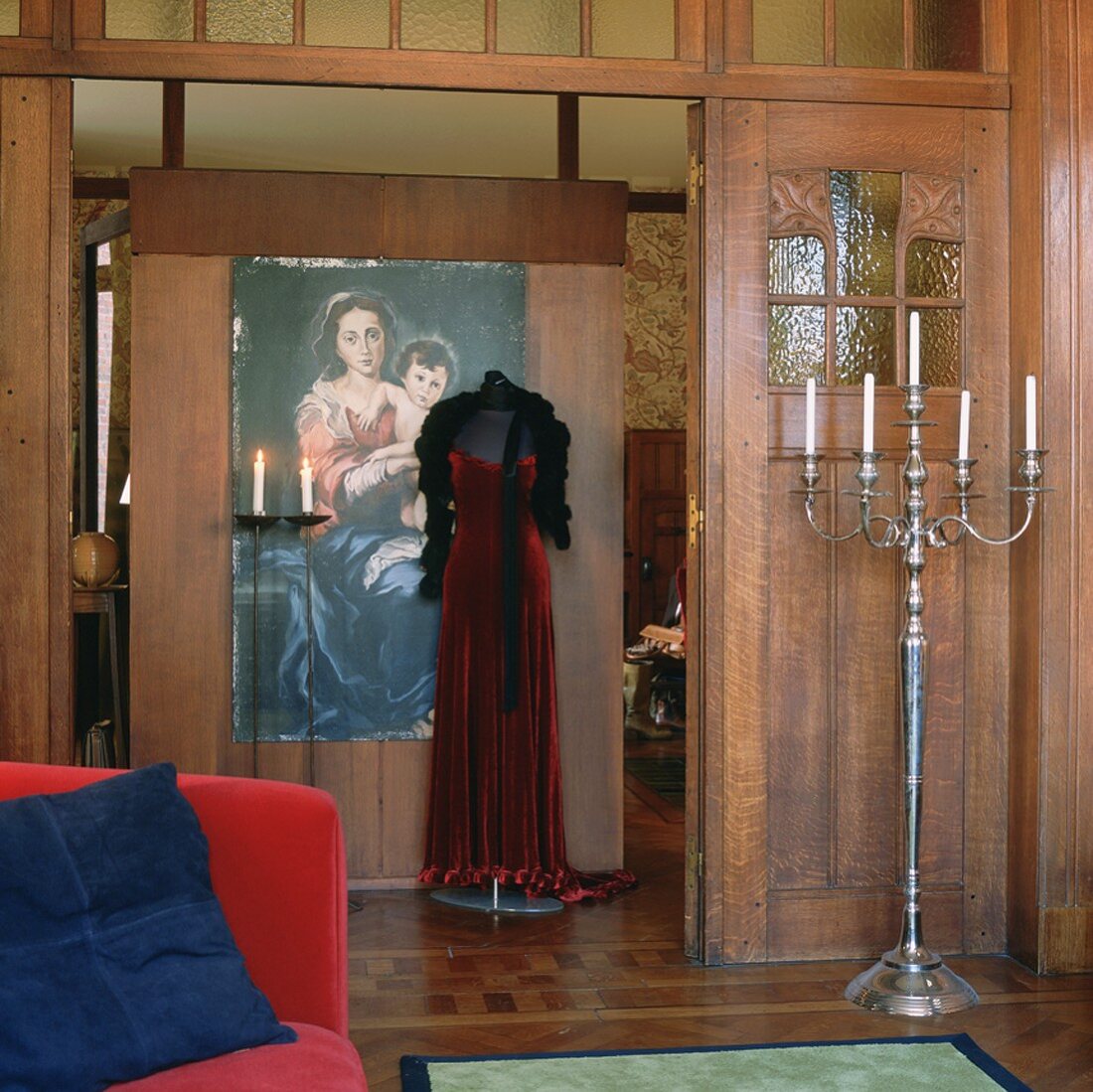 Stehkandelaber und Schaufensterpuppe mit rotem Abendkleid in einem historischen Wohnraum