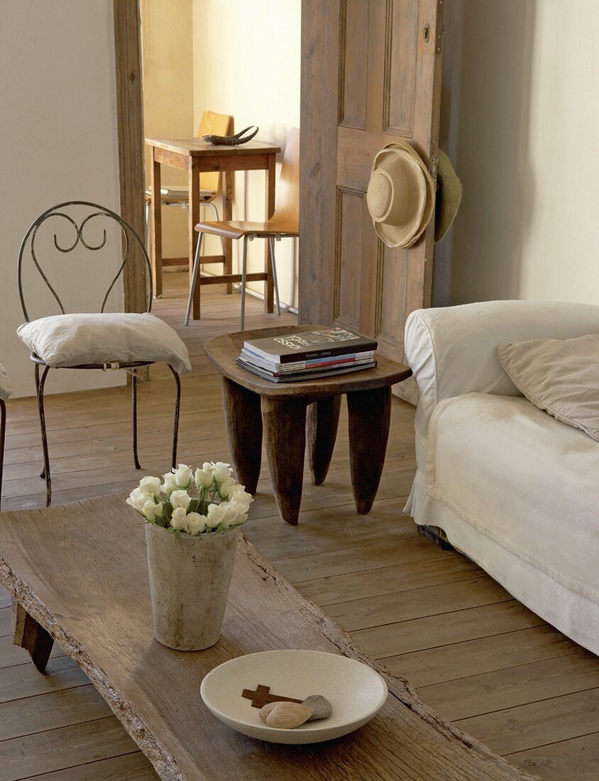 weiße Rosen auf einem rustikalen Naturholztisch im Wohnzimmer