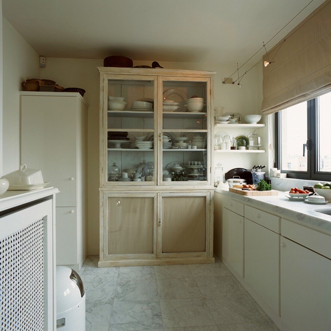 Antiker Geschirrschrank in einer schlichten Küche mit Marmorboden