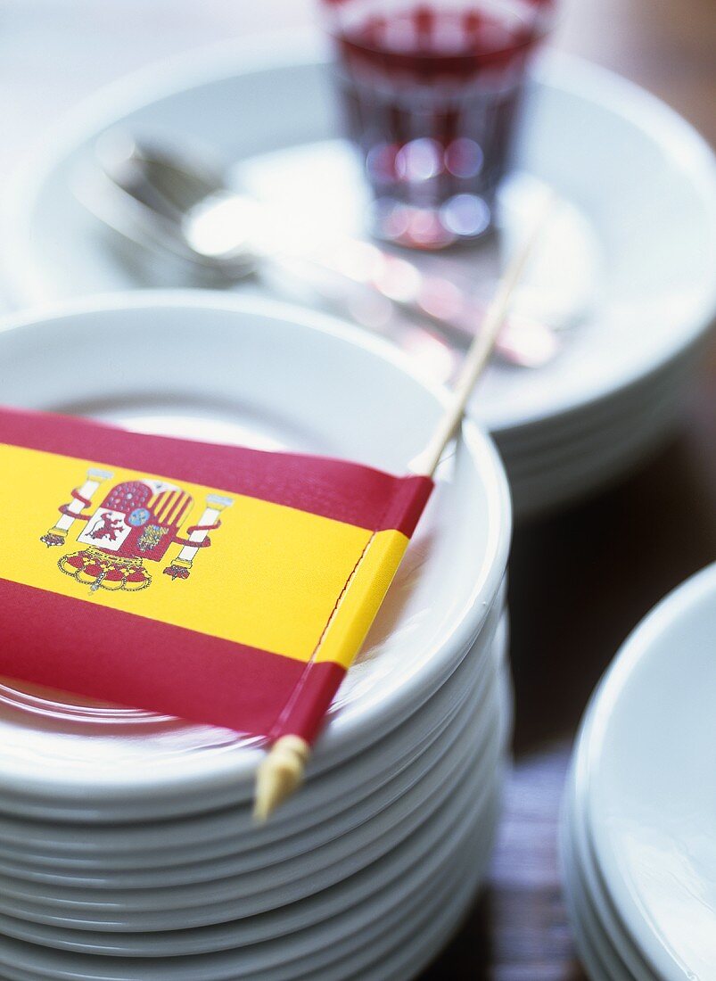 Deko für ein spanisches Fest: Fähnchen auf einem Tellestapel
