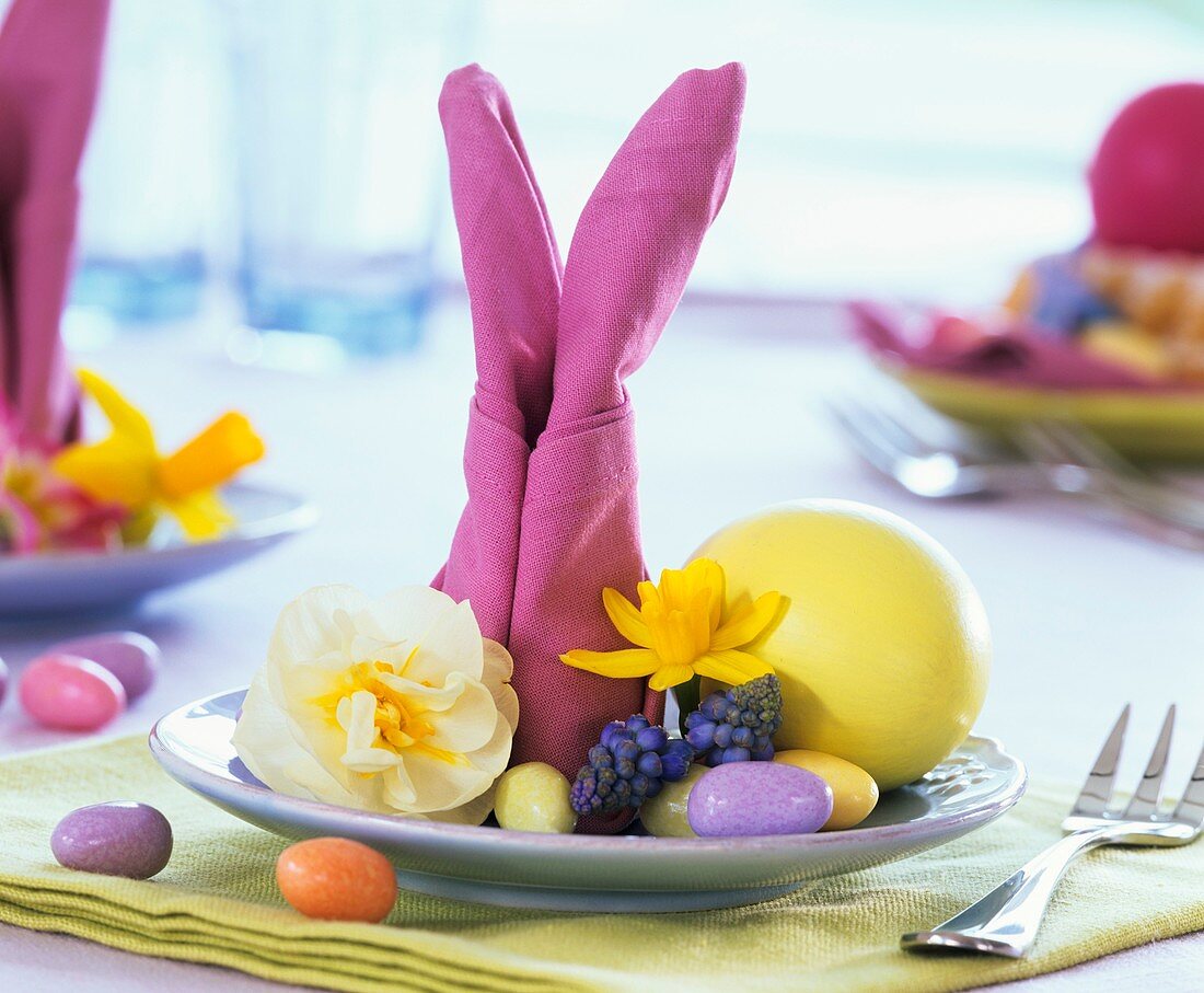 Osterteller mit Blumen, Eiern & Serviette als Osterhase gefaltet