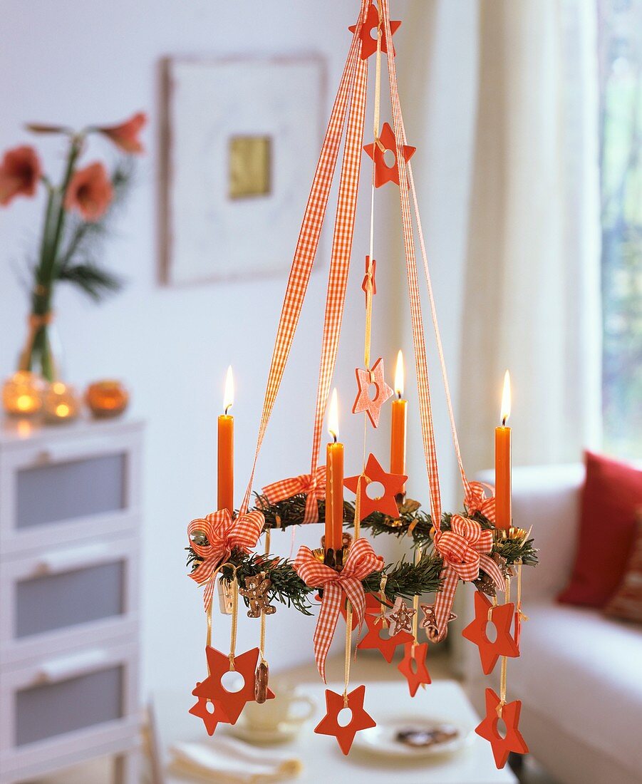 Hanging Advent wreath with fir, candles, stars, gingerbread