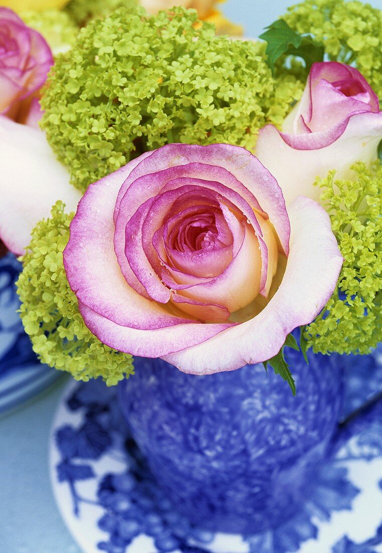 Blaue Vase mit rosafarbenen Rosen