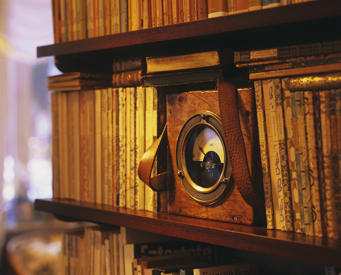 Shelf of antique books with old ammeter