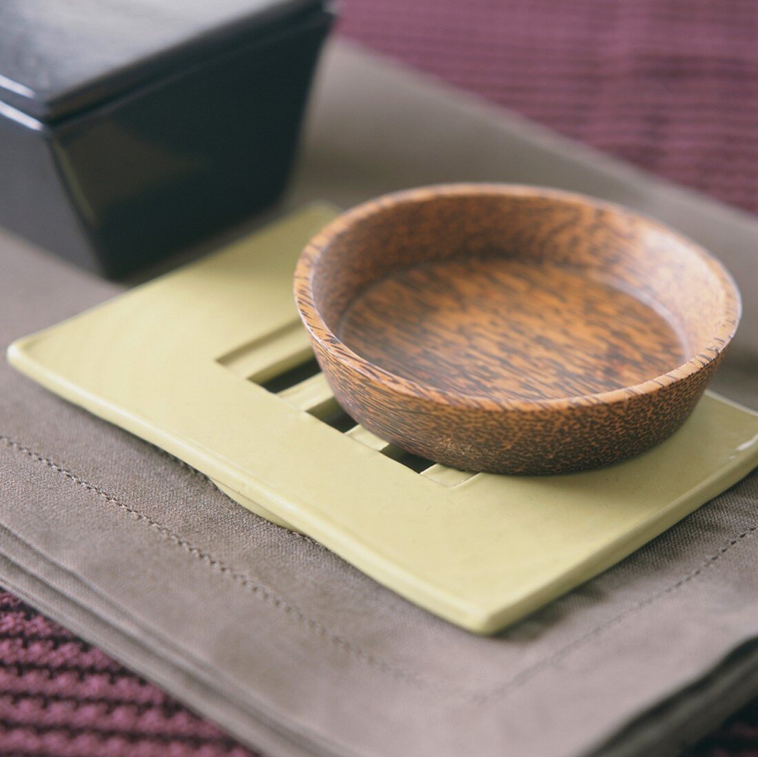 Wooden bowl on ceramic dish