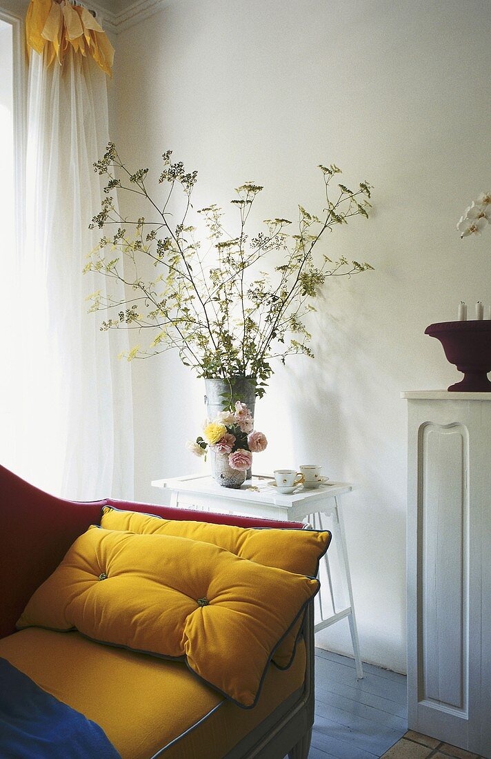 A bunch of flowers in a corner of a living room