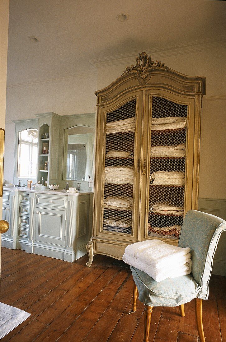 Badezimmer in Landhaus mit Dielenboden, Waschtisch aus Holz & antikem Wäscheschrank
