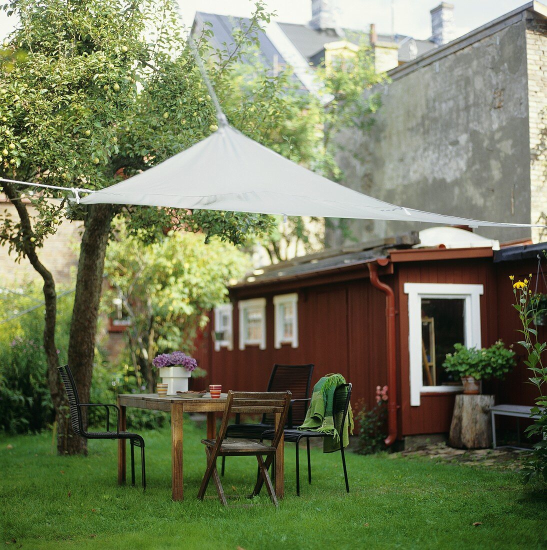 Gartentisch mit Stühlen und Sonnensegel im Freien
