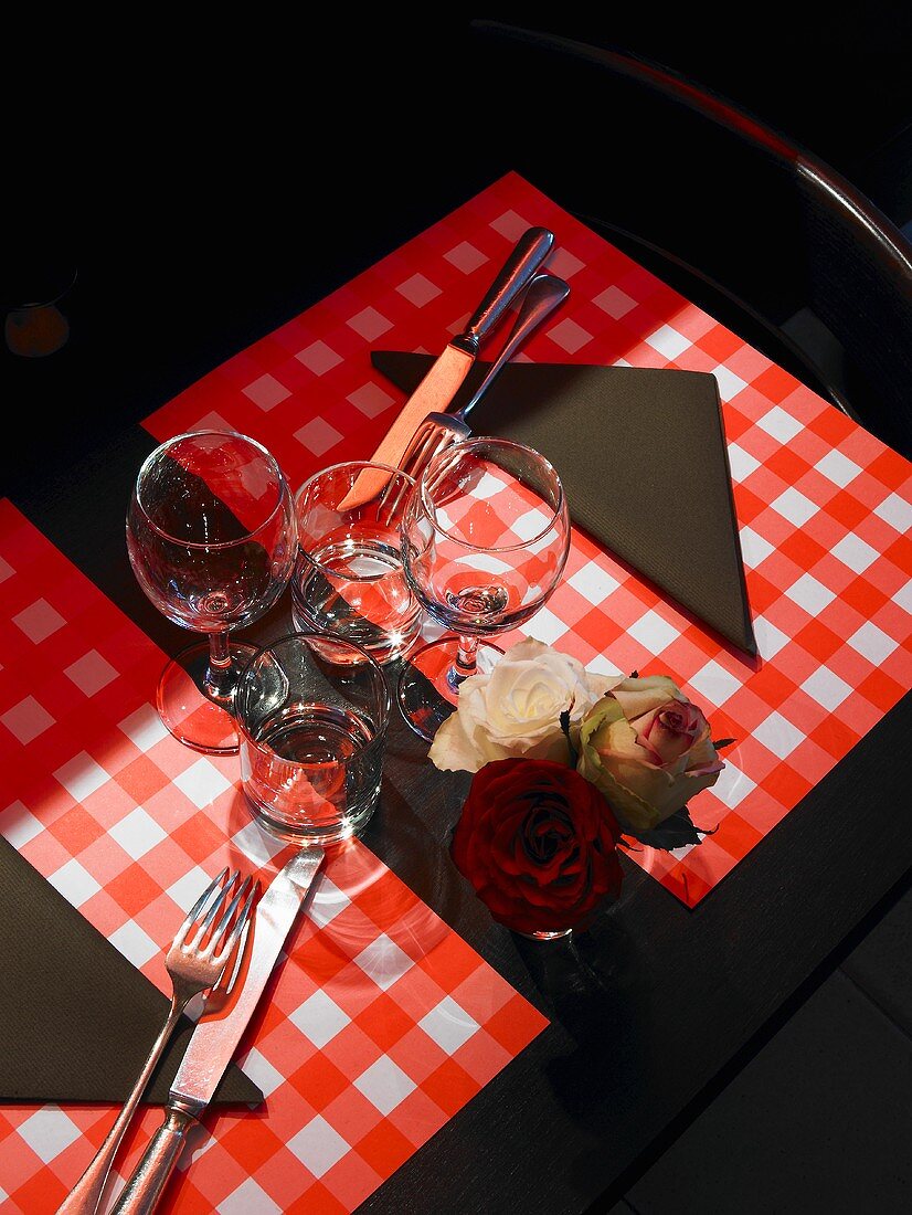 Table laid for two with roses in a vase