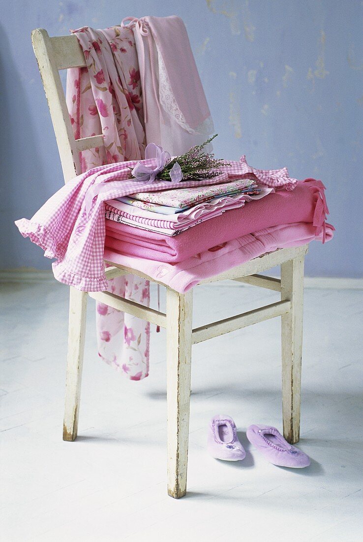 Bedding and clothes on wooden chair