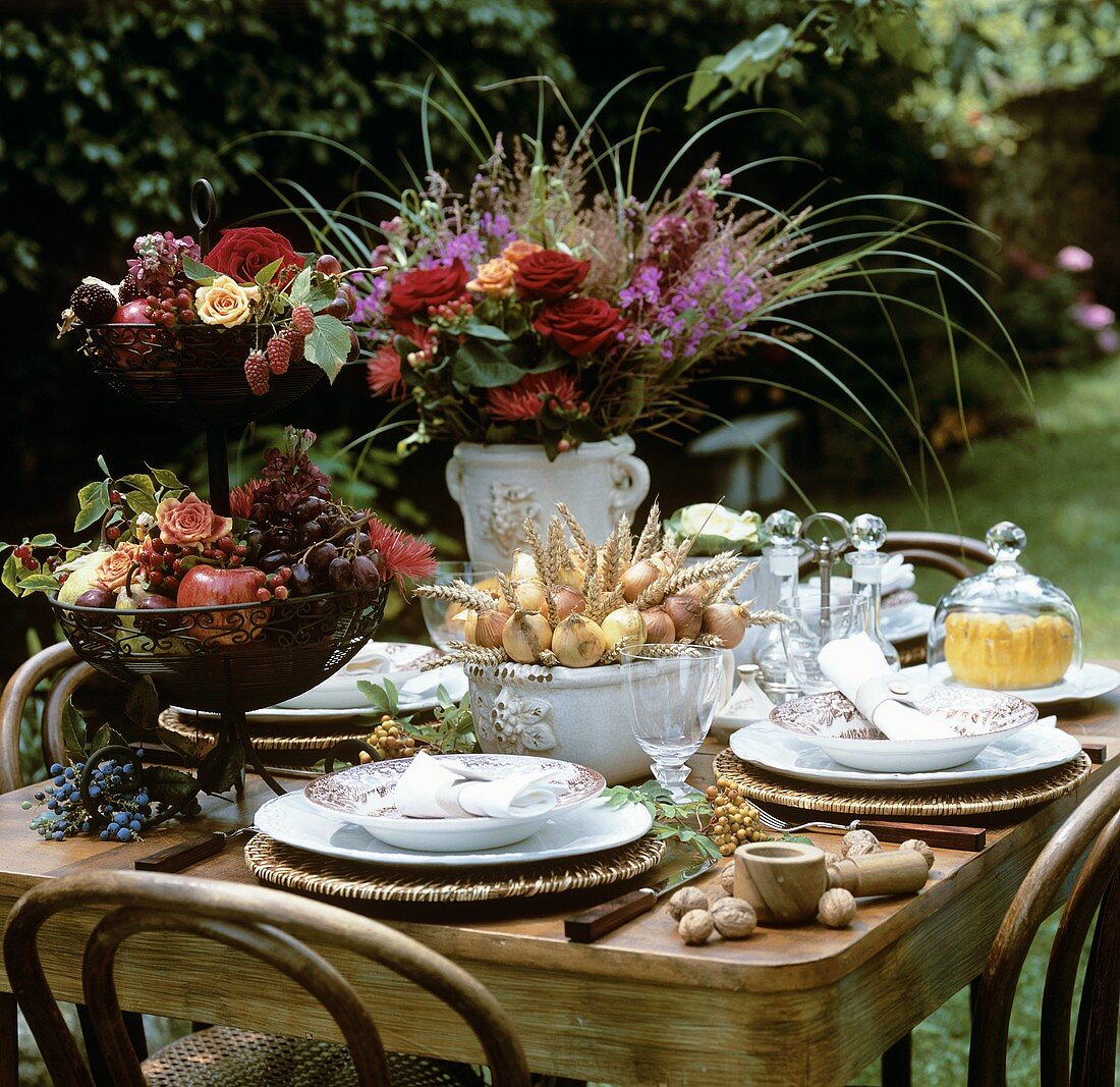 Summery table decorated with flowers and fruit out of doors