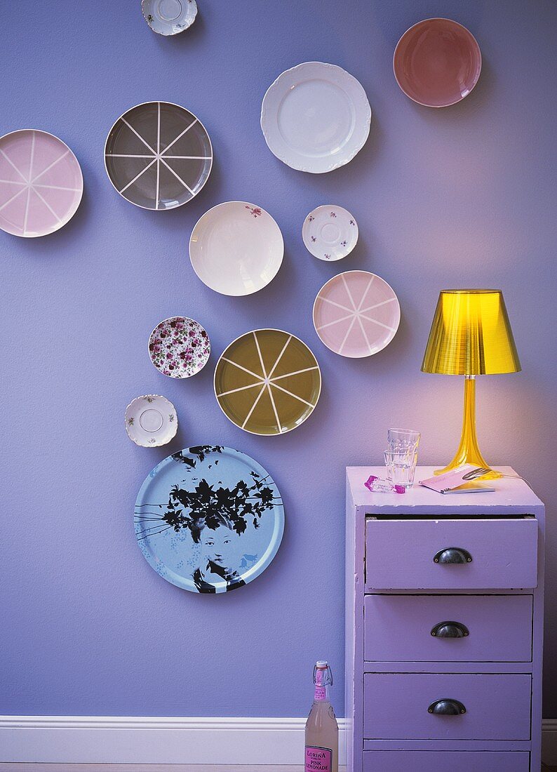Decorative plates hanging on a lilac-coloured wall