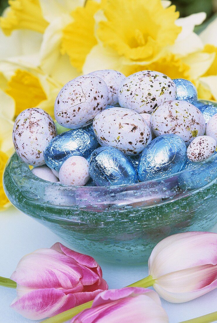 Blaue Glasschale mit Ostereiern und Frühlingsblumen
