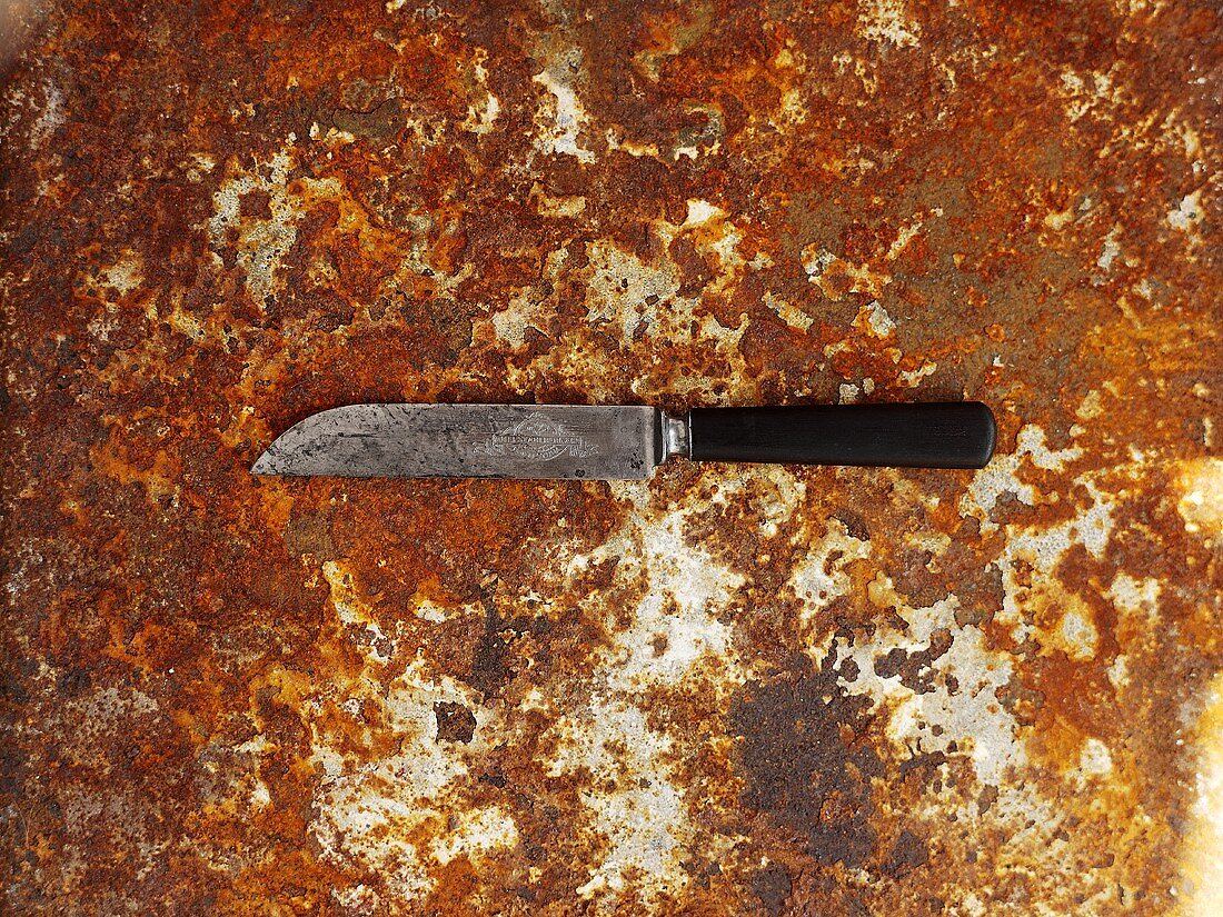 Messer auf rostigem Backblech von oben