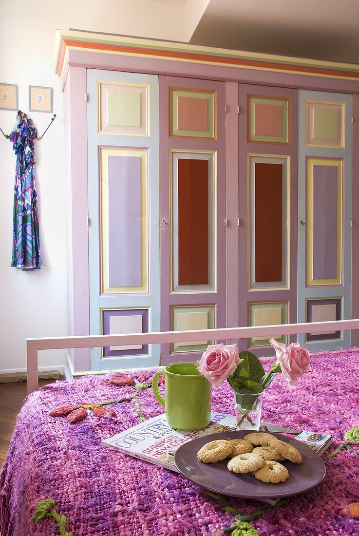 A tea break in a bedroom with a painted country house-style cupboard