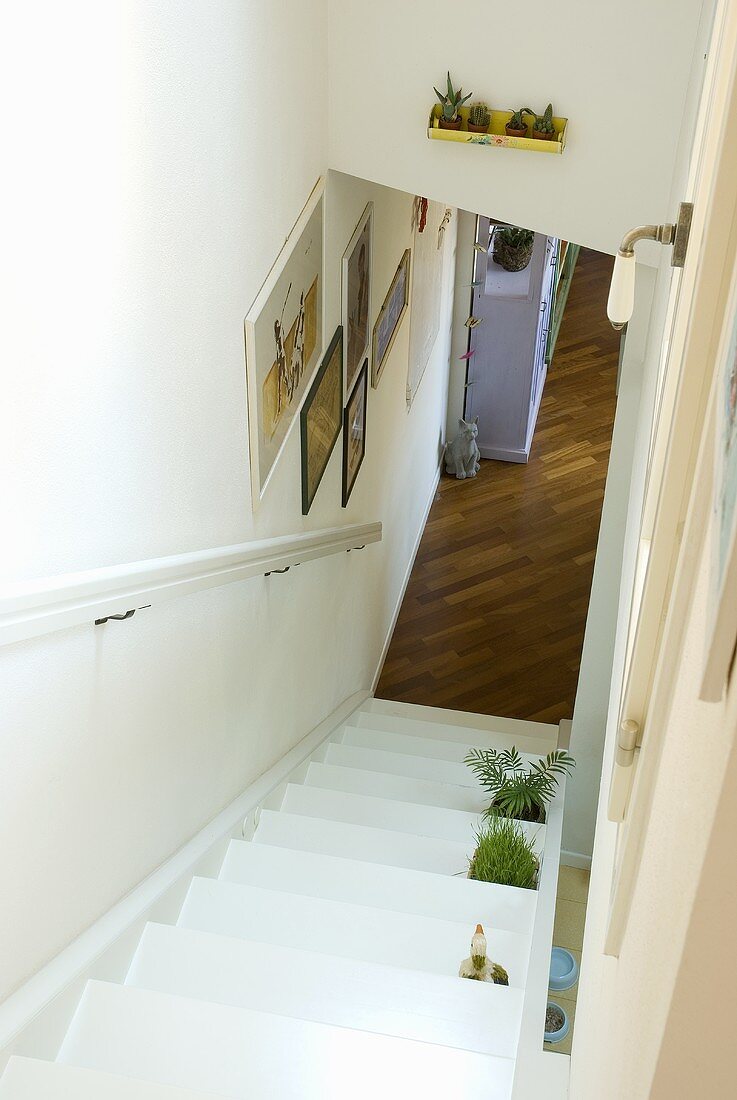 A white wooden staircase with a view of a parquet floor