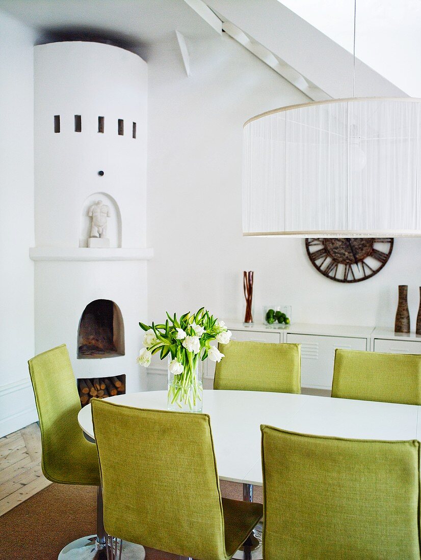 Esszimmer mit ovalem Tisch, grünen Stühlen & Eck-Kamin