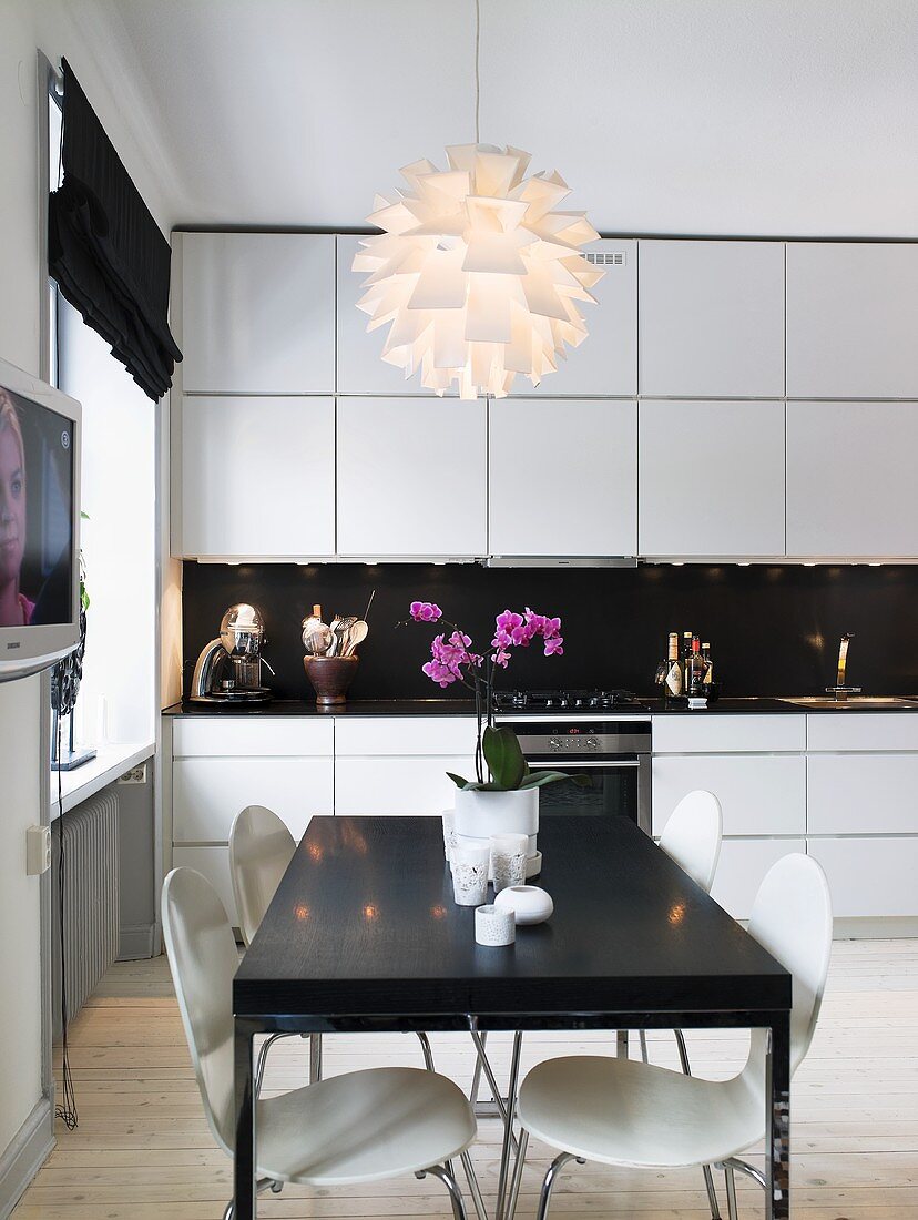 Küche in Weiß und Schwarz mit Esstisch, Küchenstühlen & moderner Deckenleuchte