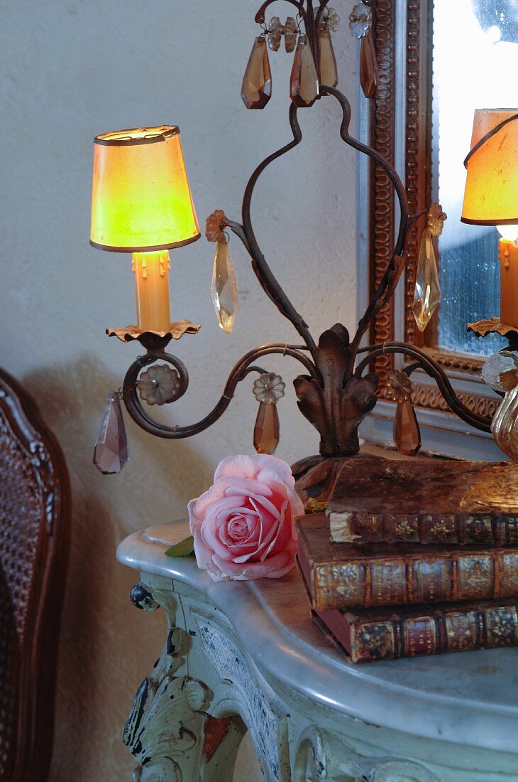 Lampe und antike Bücher auf Beistelltisch