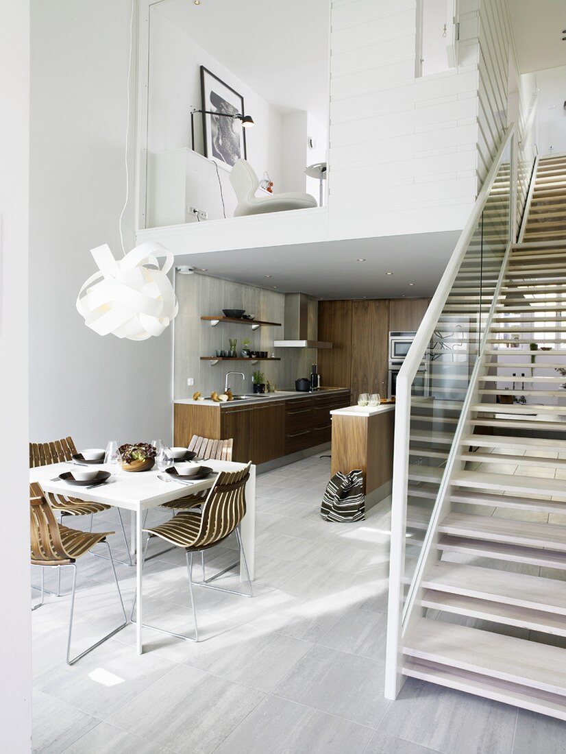 Offener, moderner Wohnraum mit Küche, Essbereich & Treppe zur Galerie