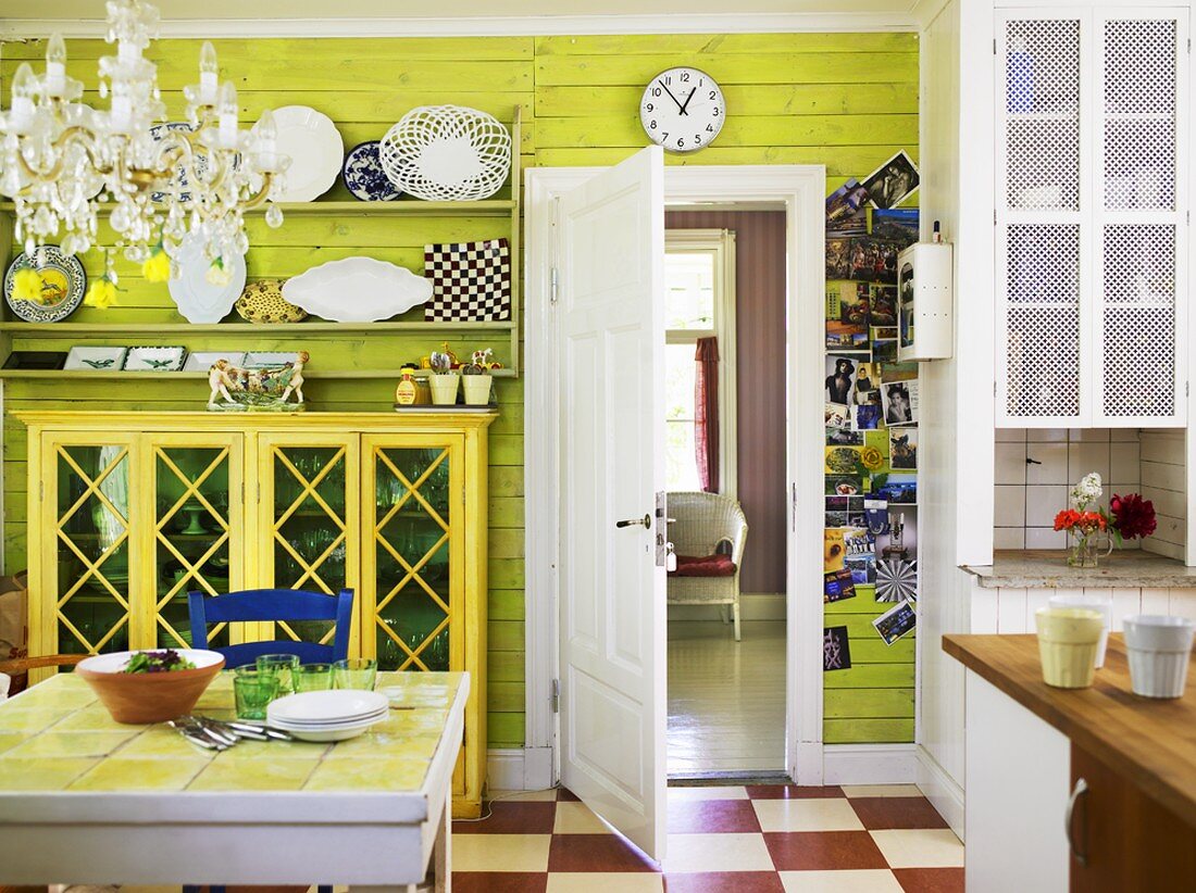 Wohnküche mit grüner Holzvertäfelung, Sideboard, Tellerregalen & Esstisch