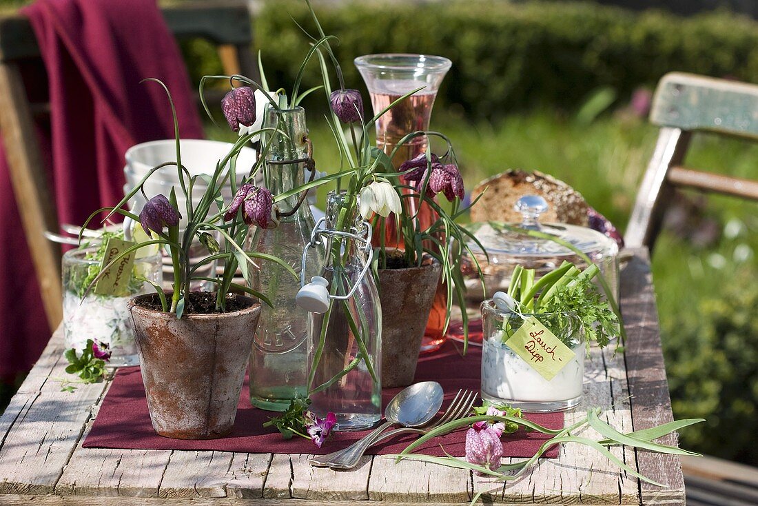 Frittilaria in Bügelflaschen und im Blumentopf als Tischdeko