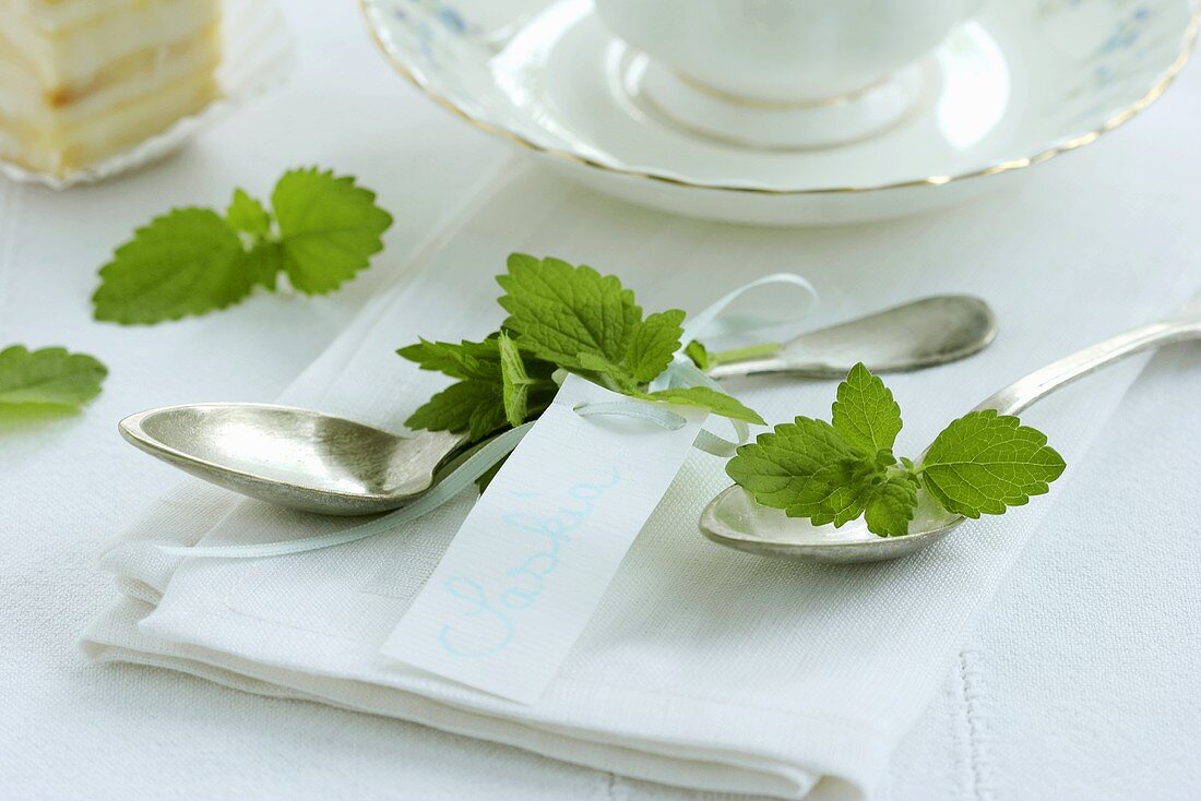 Silver spoons with peppermint leaves (table decoration)
