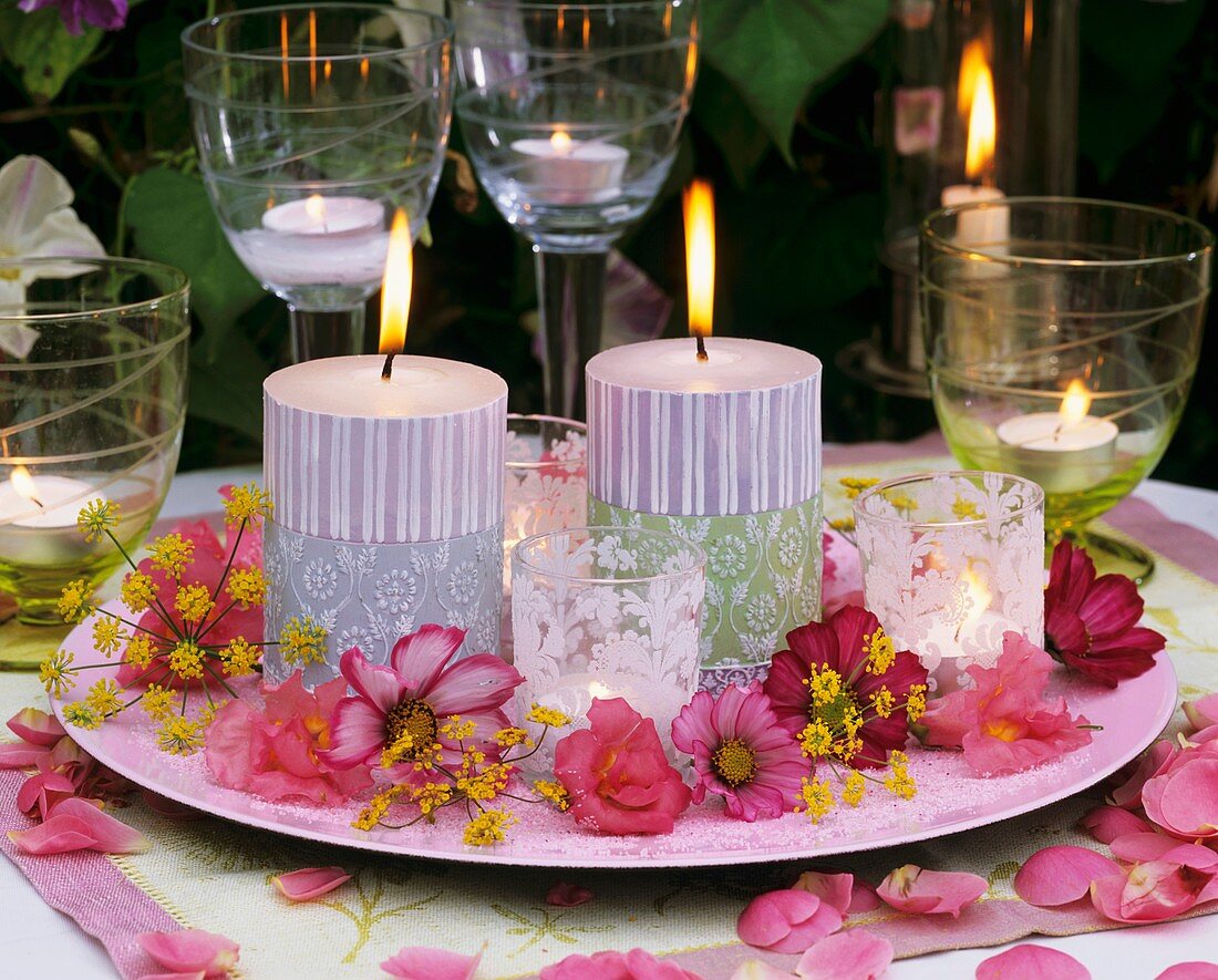 Teller mit Kerzen, Windlichtern und Blüten von Schmuckkörbchen, Löwenmäulchen und Fenchel