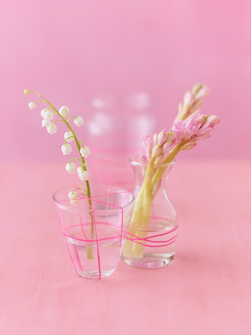 Maiglöckchen im Glas und Hyazinthen in Vase