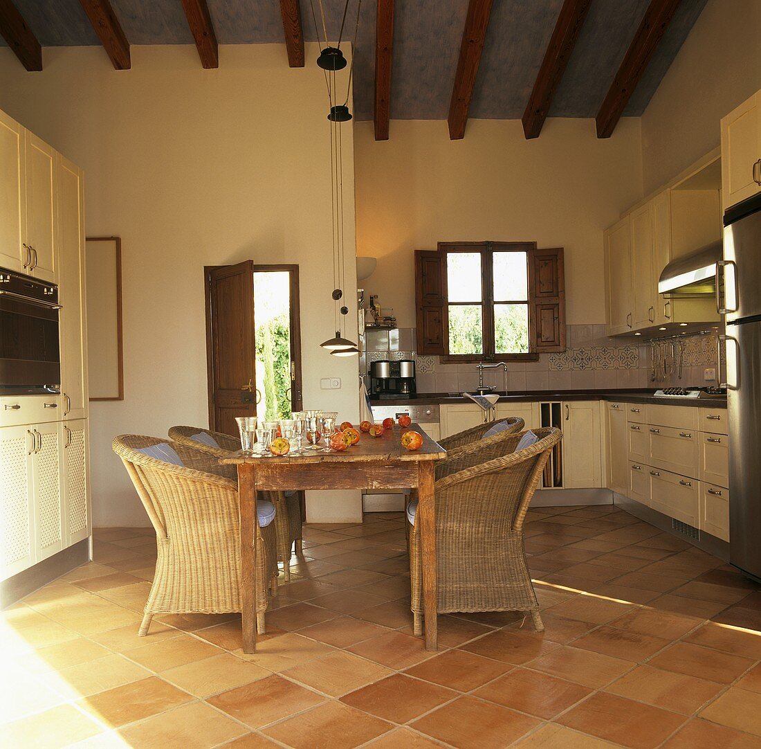 Kitchen with dining table and rattan armchairs