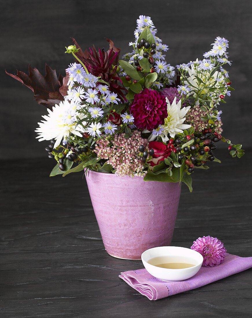Blumenstrauss in rosa Topf und Teeschale