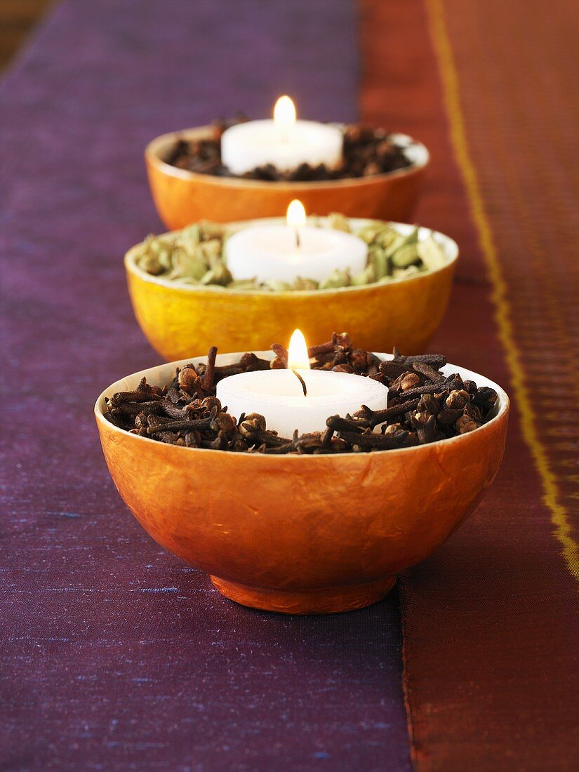 Three bowls of spices with candles