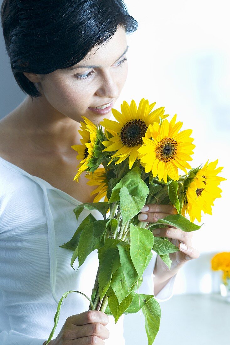 Young woman with a bunch of sunflowers