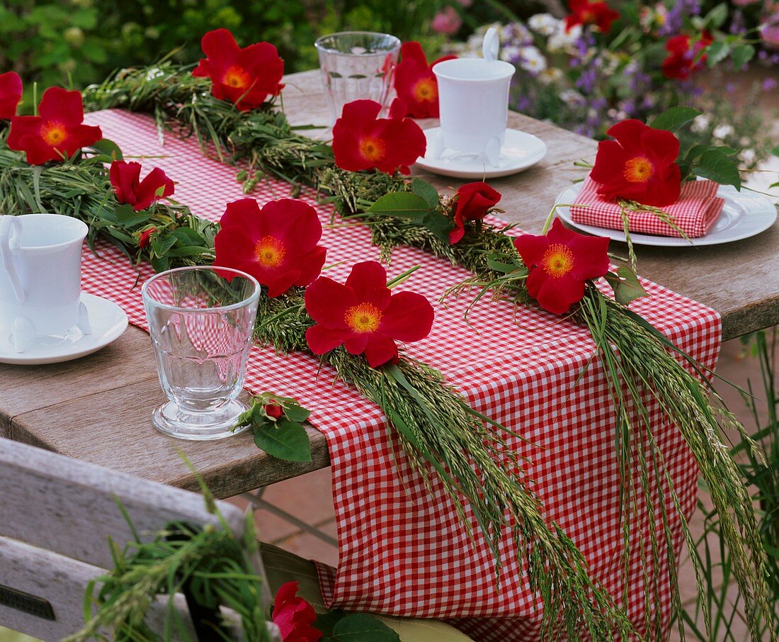 Tischdeko mit Rosenblüten und Graszöpfen