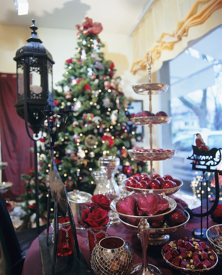 Weihnachtliche Deko auf Tisch & Etagere, im Hintergrund geschmückter Weihnachtsbaum