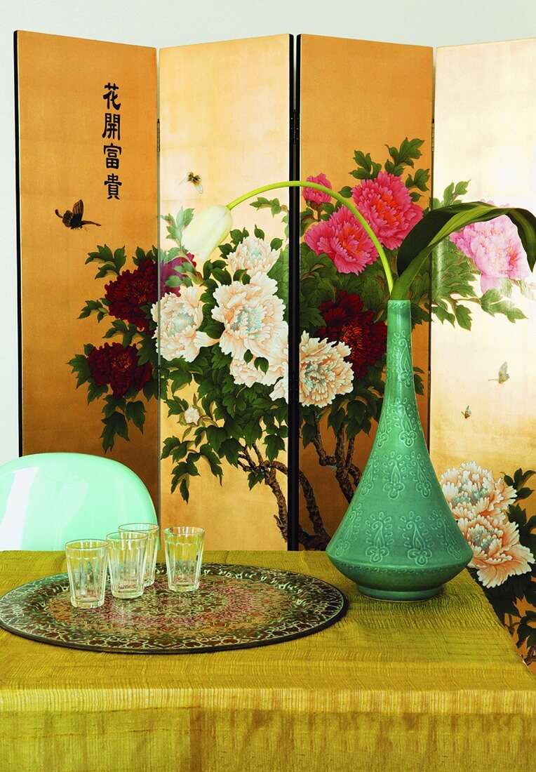 Esstisch mit Blumendeko, im Hintergrund Chinesischer Paravent