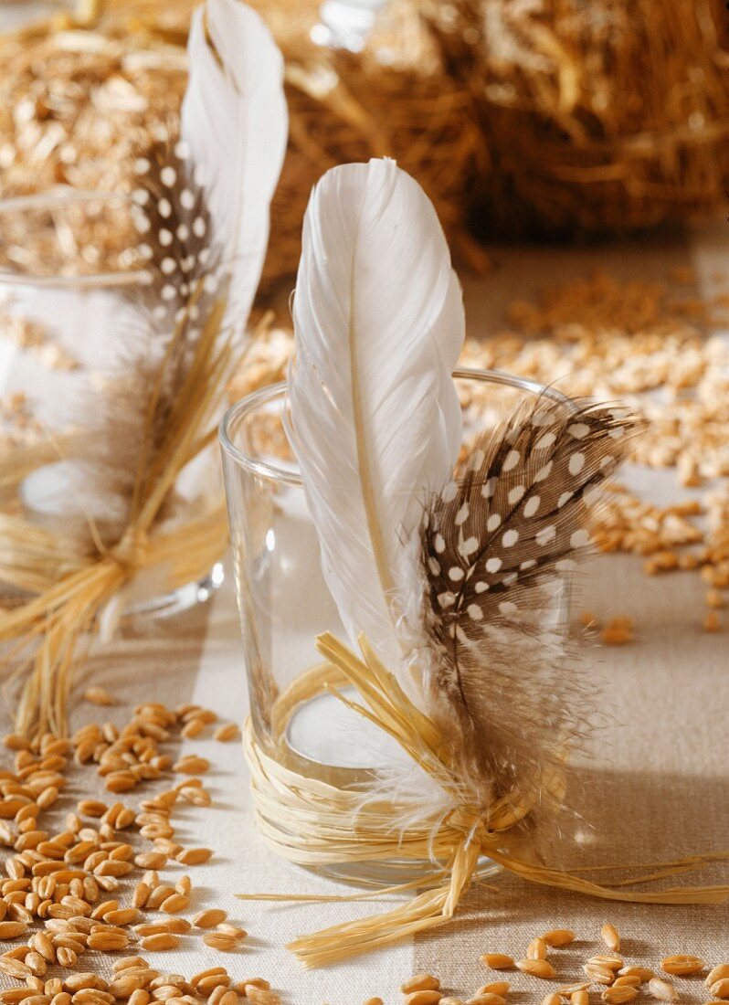 Table decoration: grains of corn and glasses with feathers