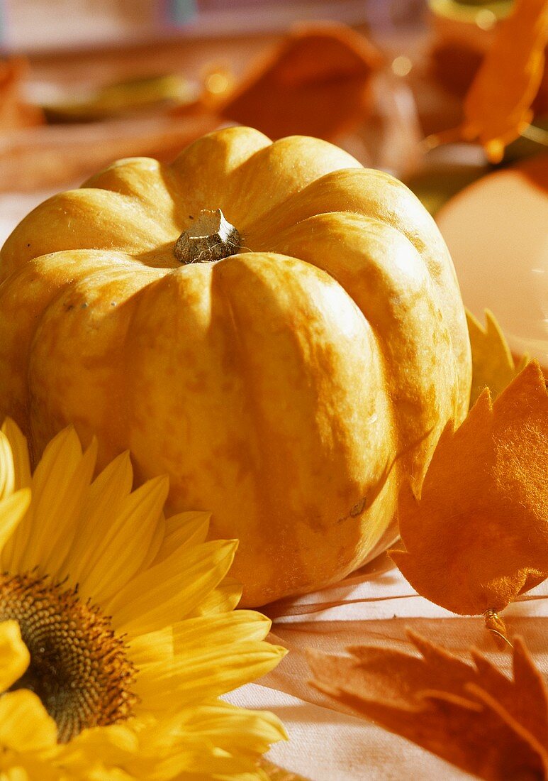 A pumpkin and sunflowers as table decoration