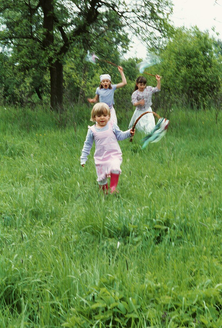 Three girls skipping through the grass