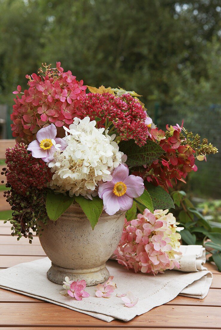An autumnal bouquet of hortensias on a garden table