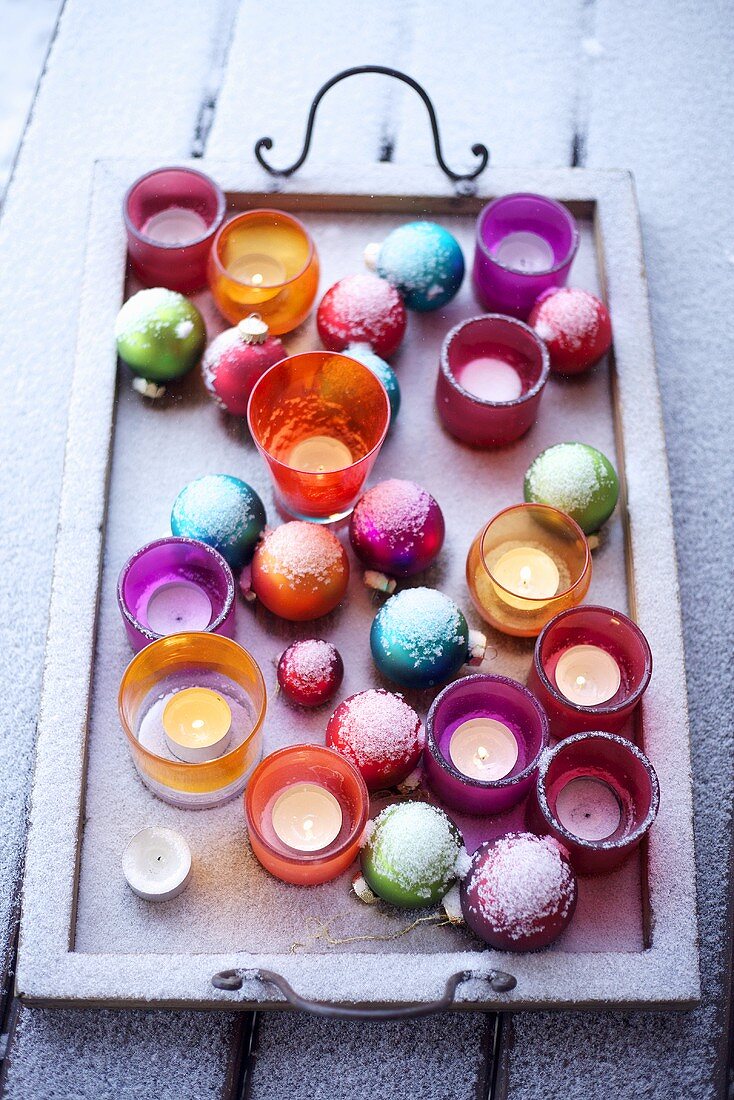 Christmas tree baubles and tea lights in a tray