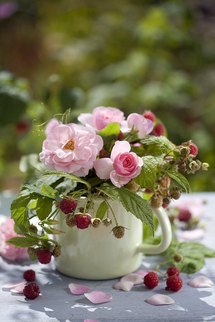 Summery table decoration of roses and raspberries