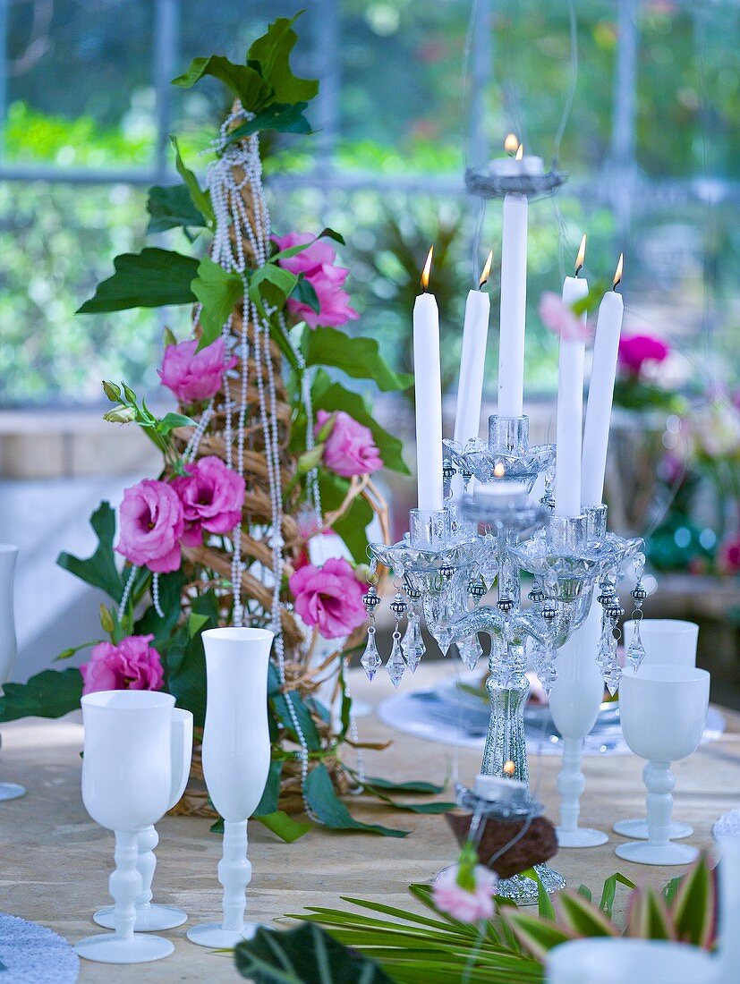 Gedeckter Tisch mit Blumenpyramide und Kerzenleuchter