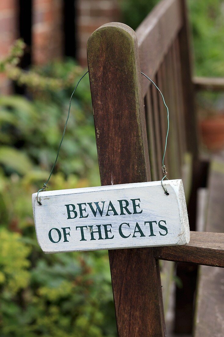 A sign on a garden bench