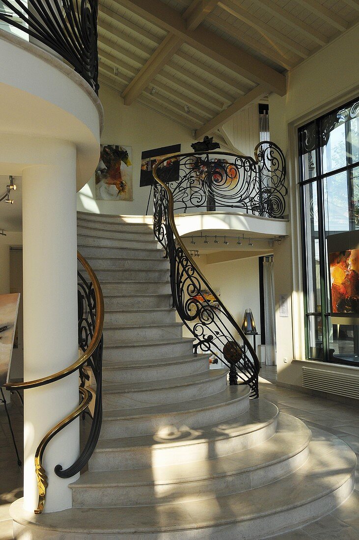 Treppenaufgang aus Marmor mit ornamentalem Metallgeländer