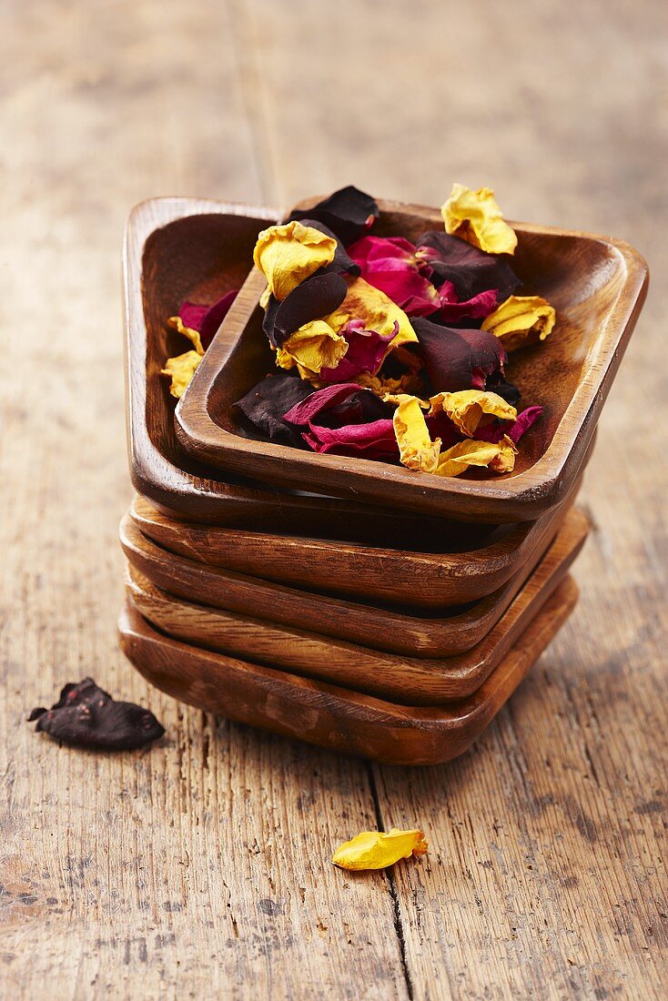 Dried rose petals in a stack of wooden bowls