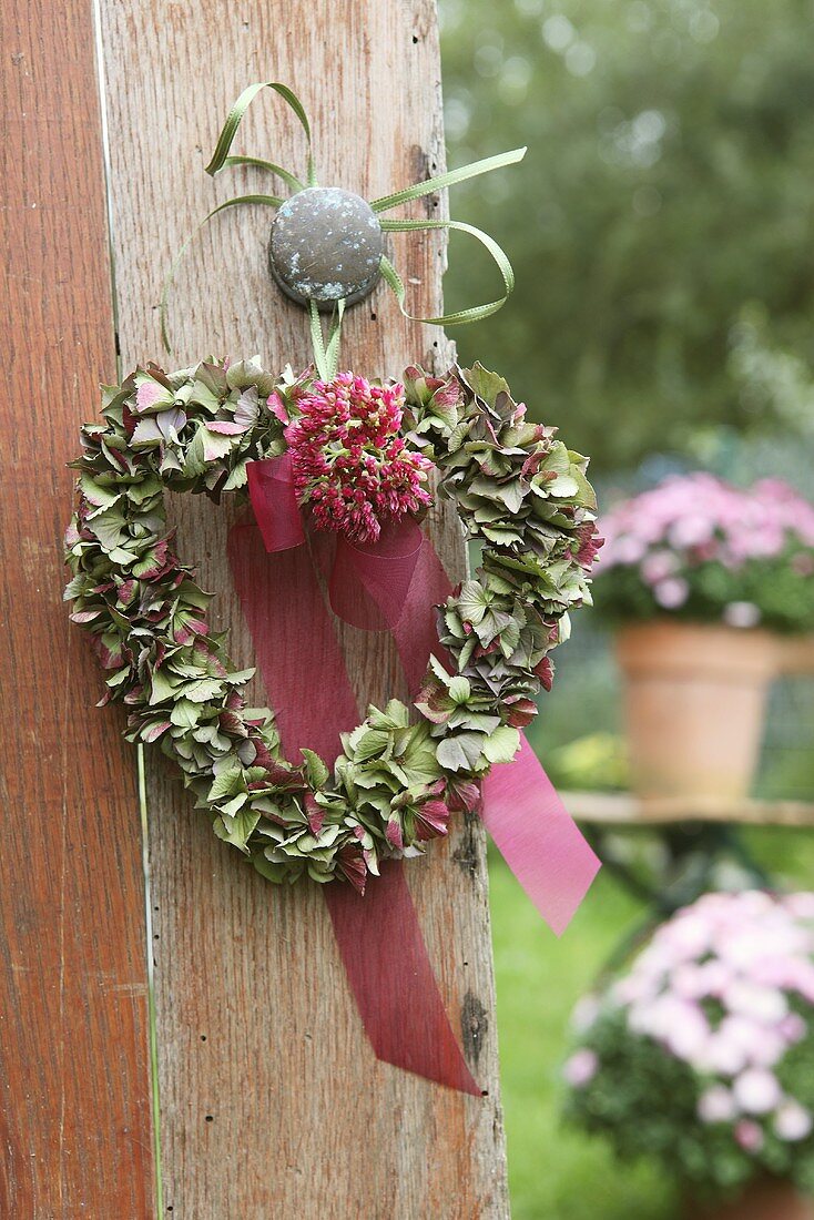 Herzförmiger Kranz aus Hortensienblüten an einer Tür